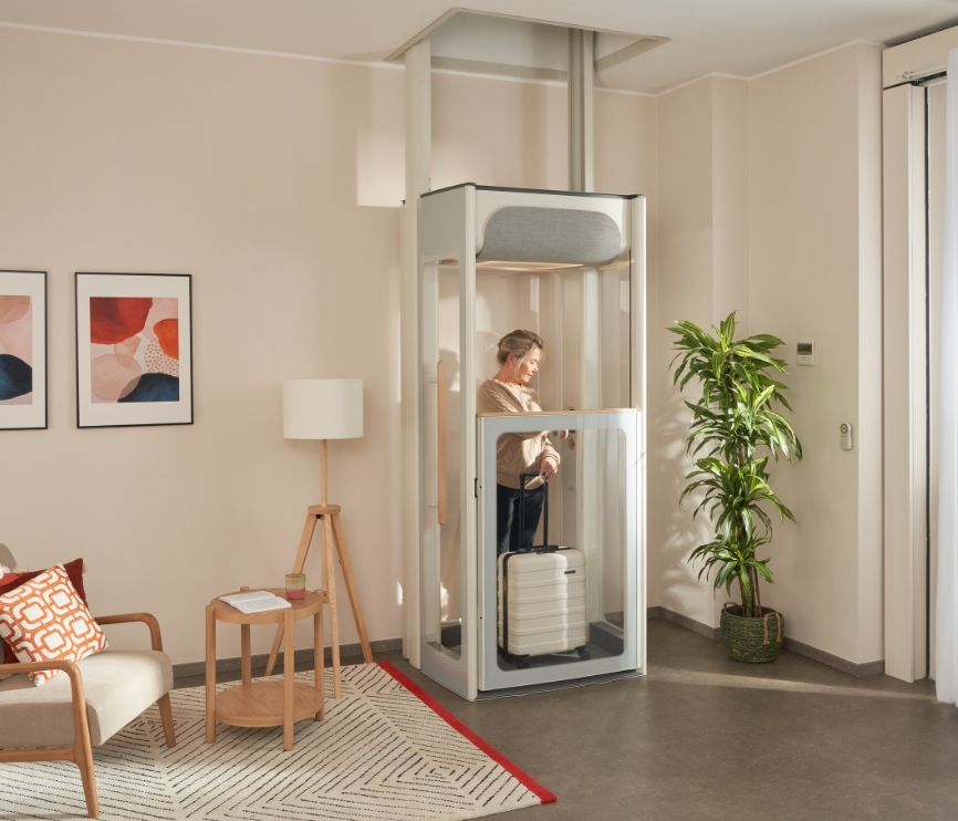 Mujer de mediana edad en su ascensor doméstico Stannah Uplifts S2.